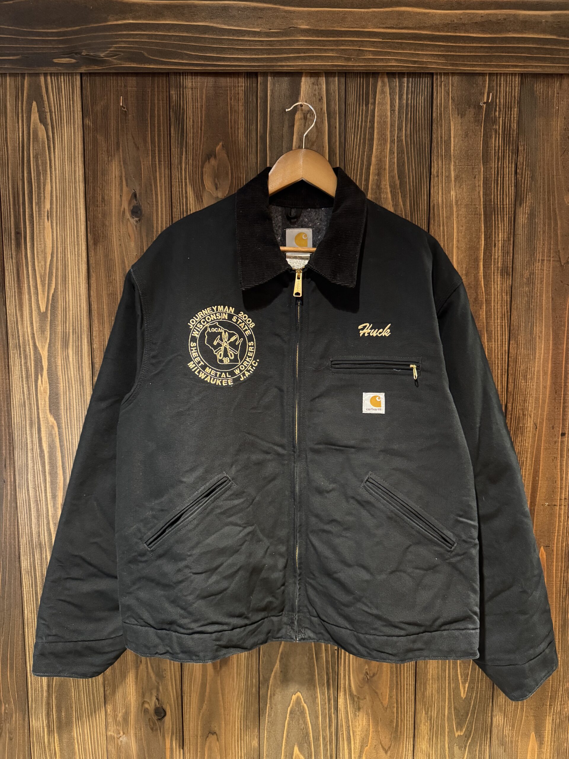 Carhartt UJ01 Journeyman カスタムジャケットのフロント全体。黒のキャンバスにゴールド刺繍が映える一着。