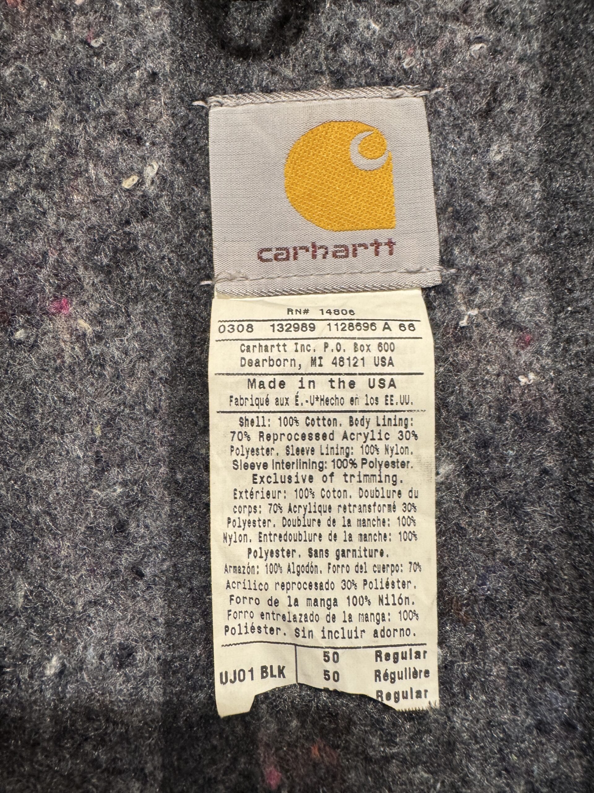 Carhartt UJ01 BLK 50 Regularの品質タグ。Made in the USA表記と素材構成。