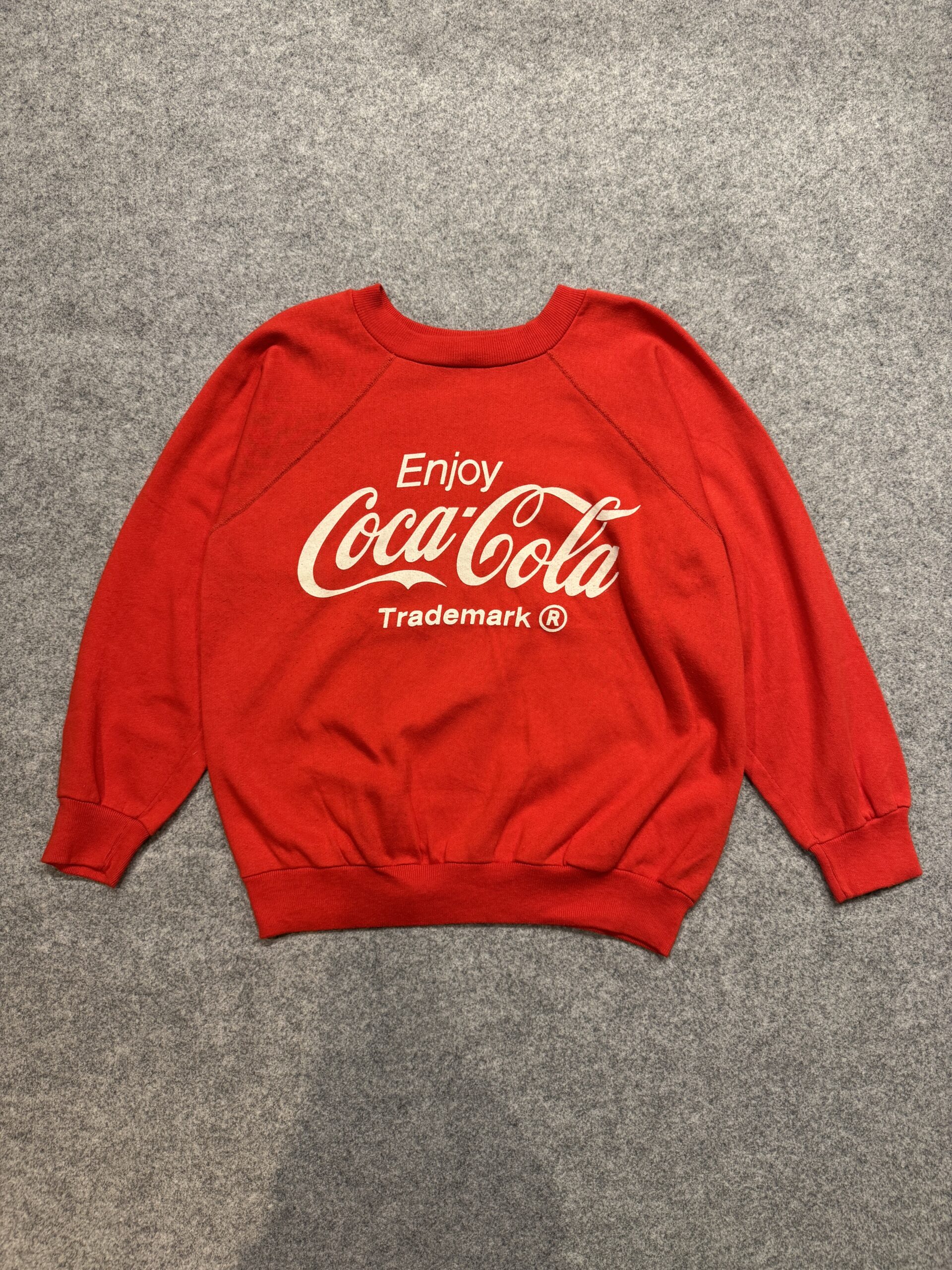 袖口リブがきゅっと締まるクラシックなスウェットディテール コカコーラ赤スウェットの袖口リブと生地感のクローズアップ