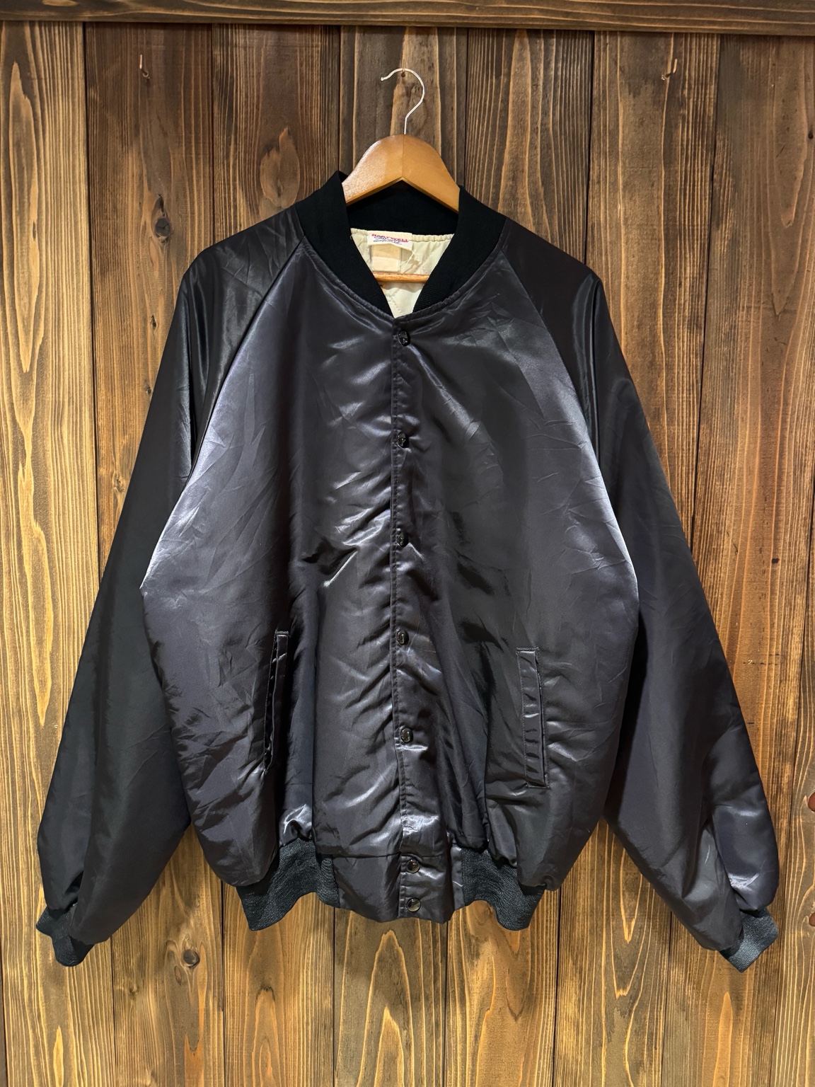 木壁に掛けられたHartwell製Rothsay Truck Stop & Cafeワークジャケットのフロント全体