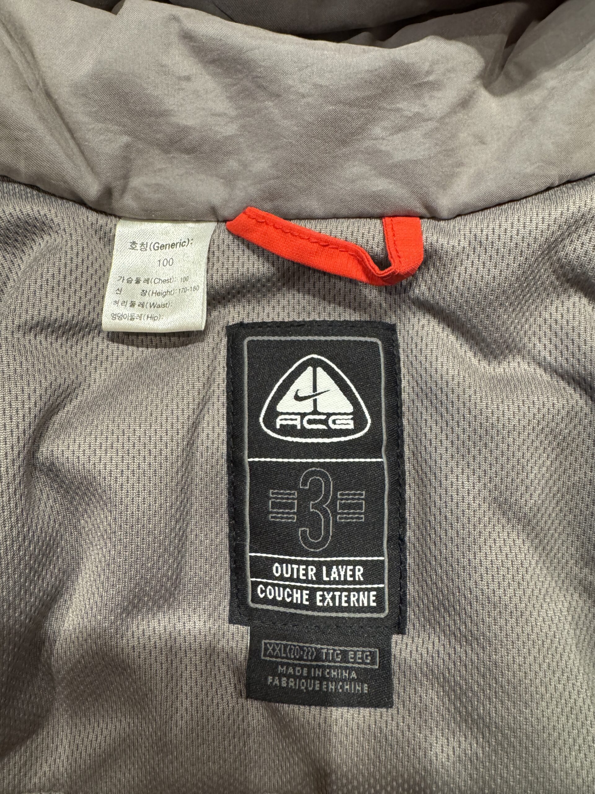 NIKE ACGロゴと3 OUTER LAYER表記、サイズ100タグのアップ