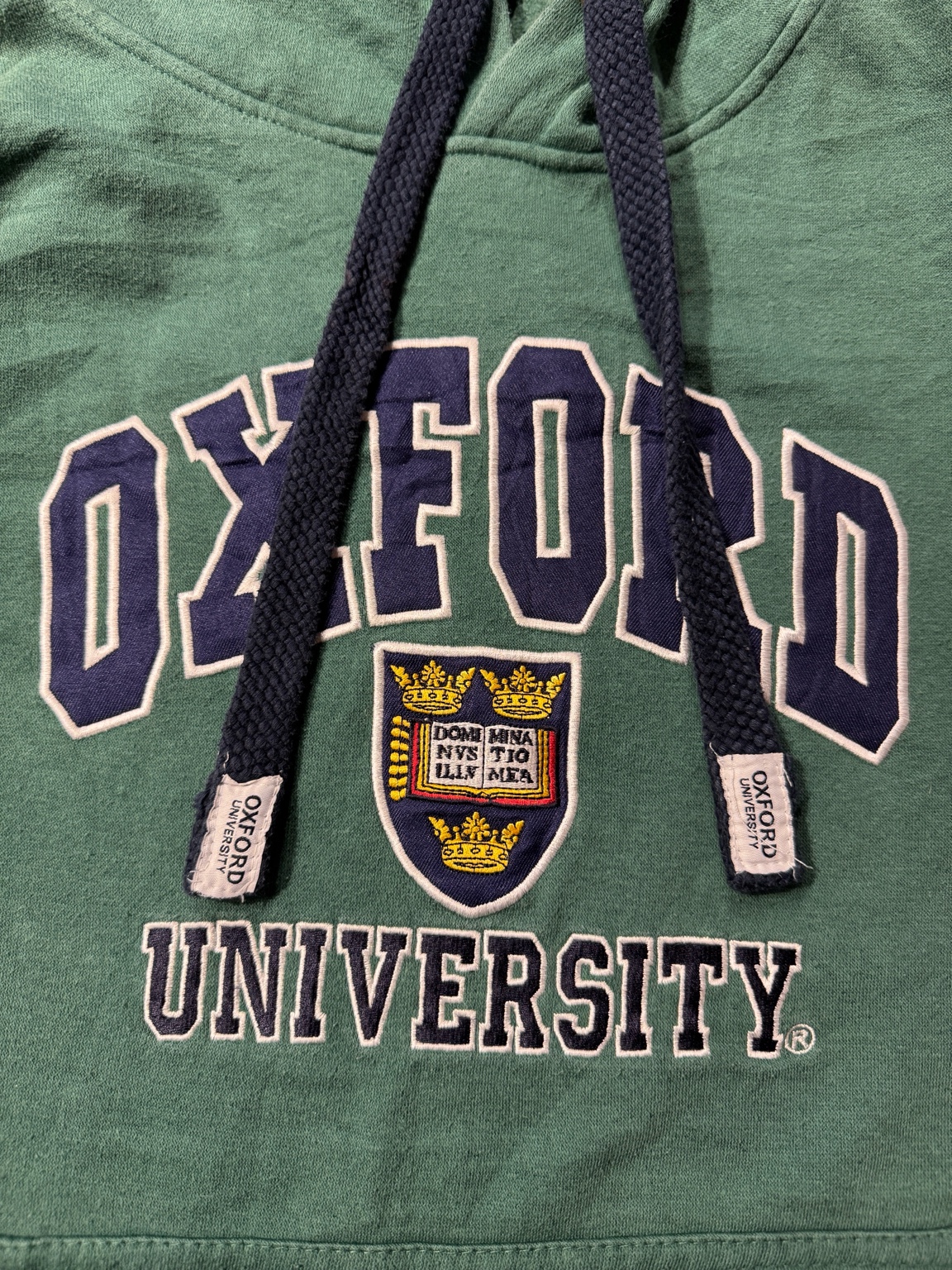 深い森みたいなフォレストグリーンに、ネイビーのカレッジロゴが