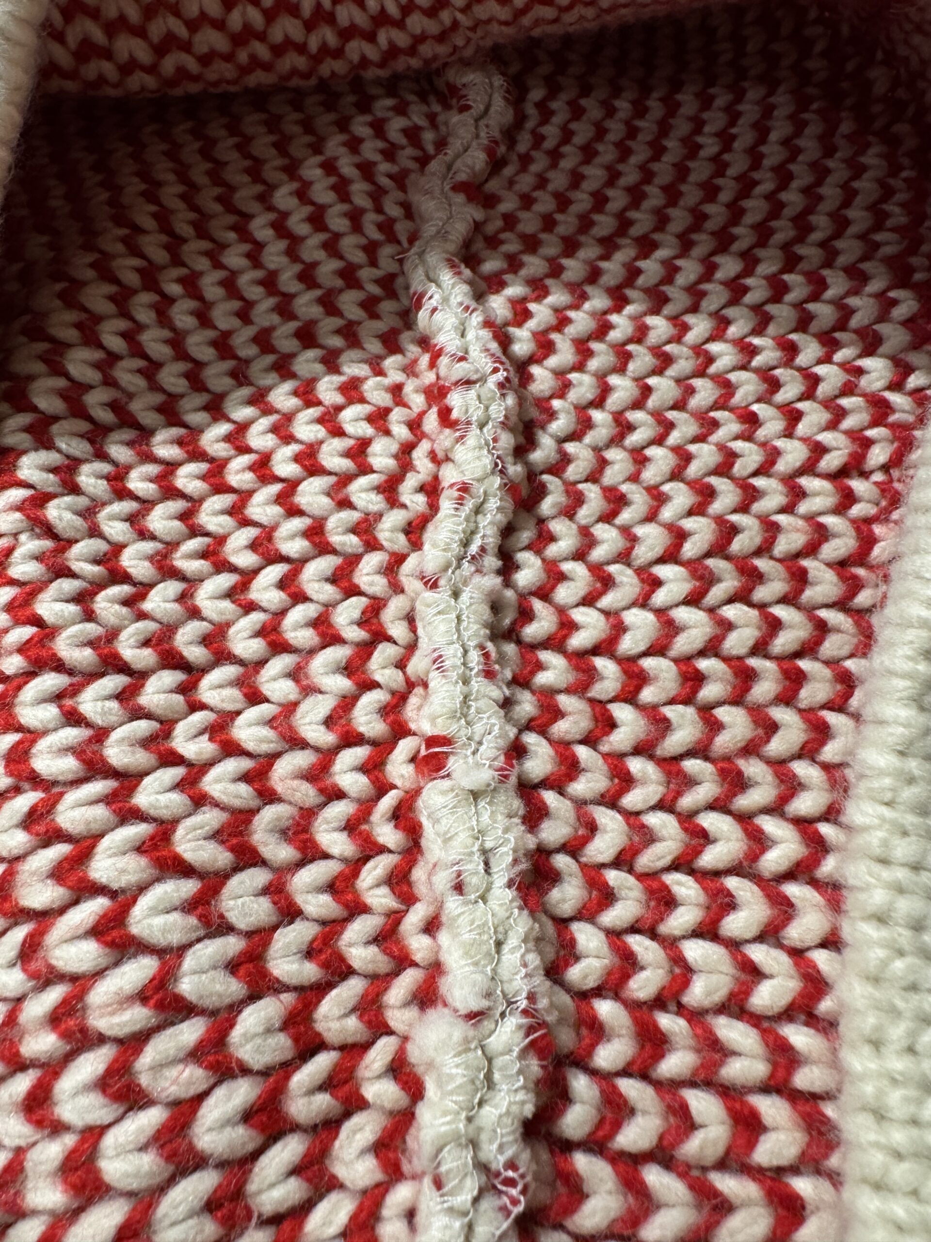 トナカイ柄フルジップニットパーカーの裏地アップ。赤とクリームの糸が交互に並んだ編み目が印象的。