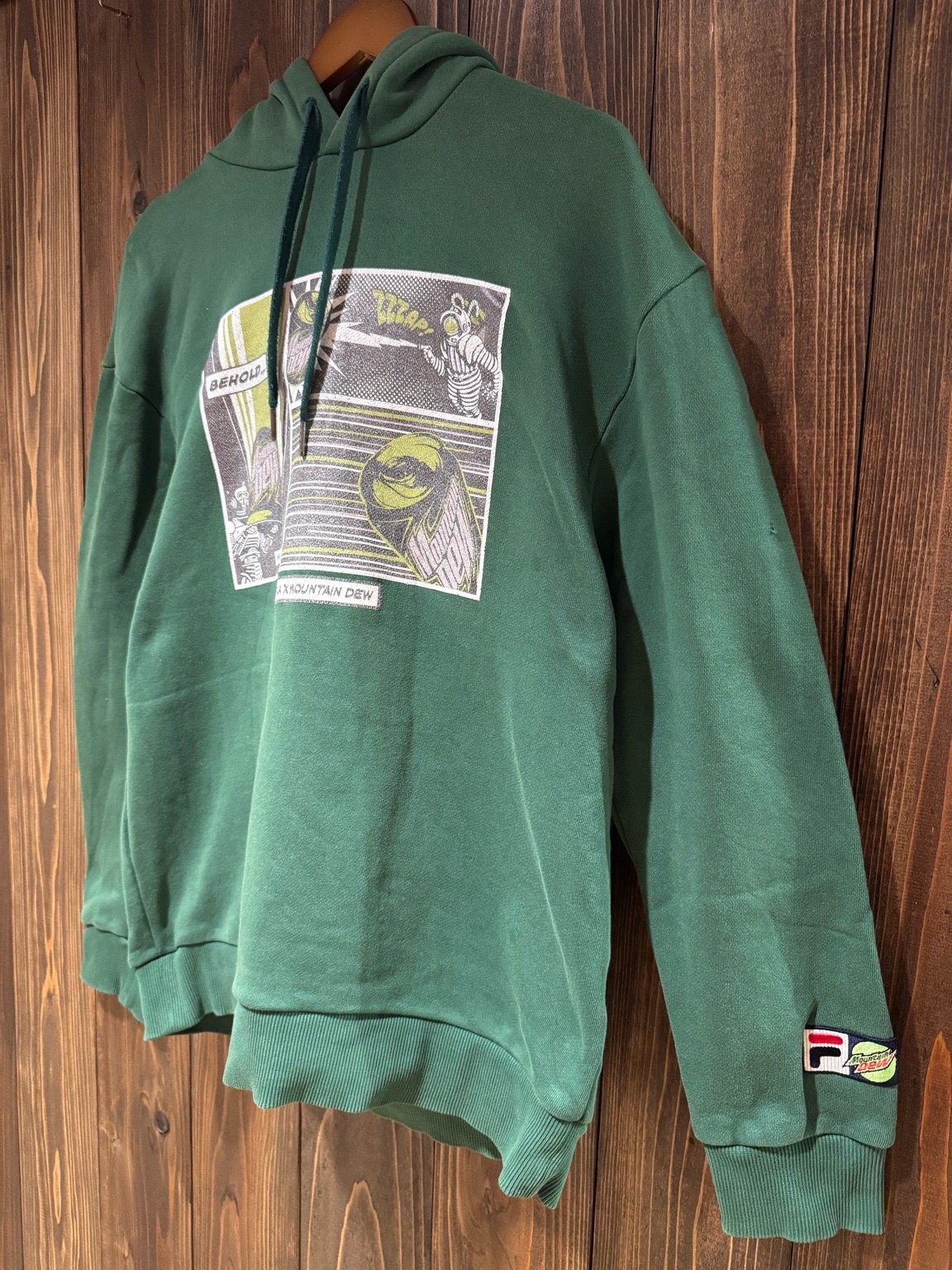 FILA × Mountain Dewフーディを斜め前から撮影したハンガー吊り写真。立体的なシルエットが分かる。