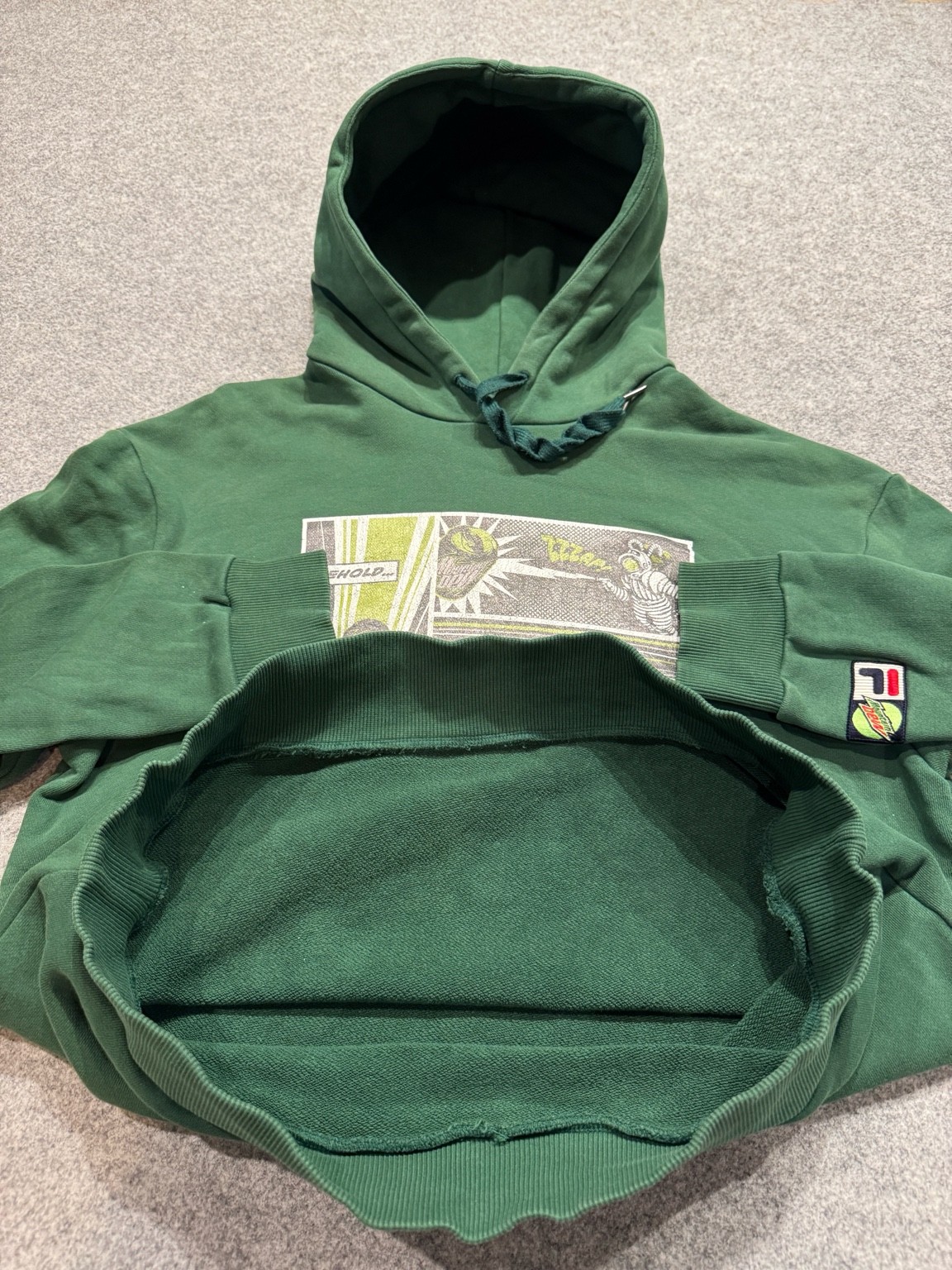 FILA × Mountain Dewフーディの裾をめくって撮影した、裏毛スウェット生地のアップ写真。