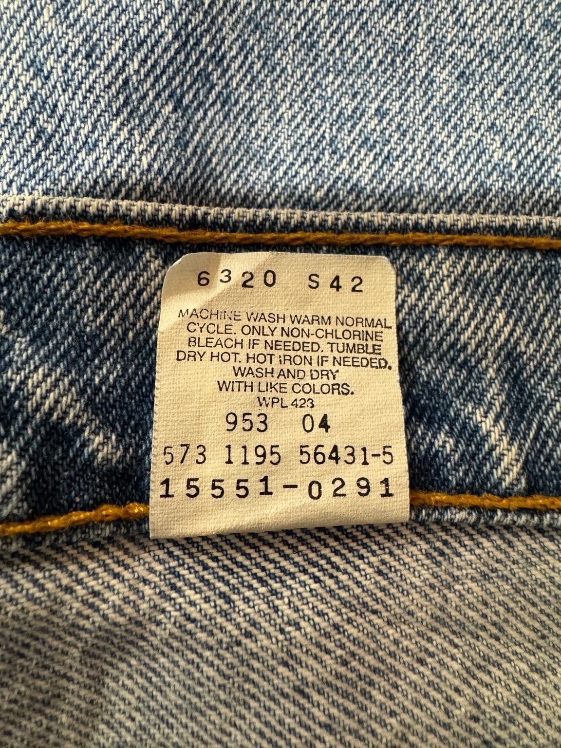 ケアタグのアップ。品番15551-0291などの数字が並んだタグ。