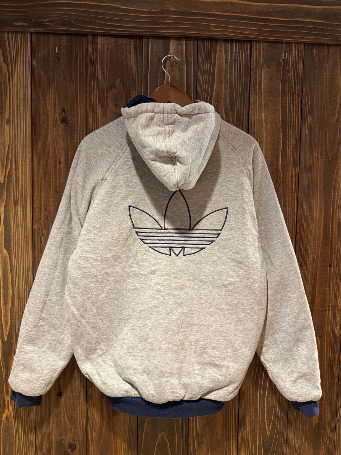 グレースウェット面を表にしたアディダスリバーシブルフーディのバックスタイル。背中に大きなトレフォイルロゴ刺繍入り。