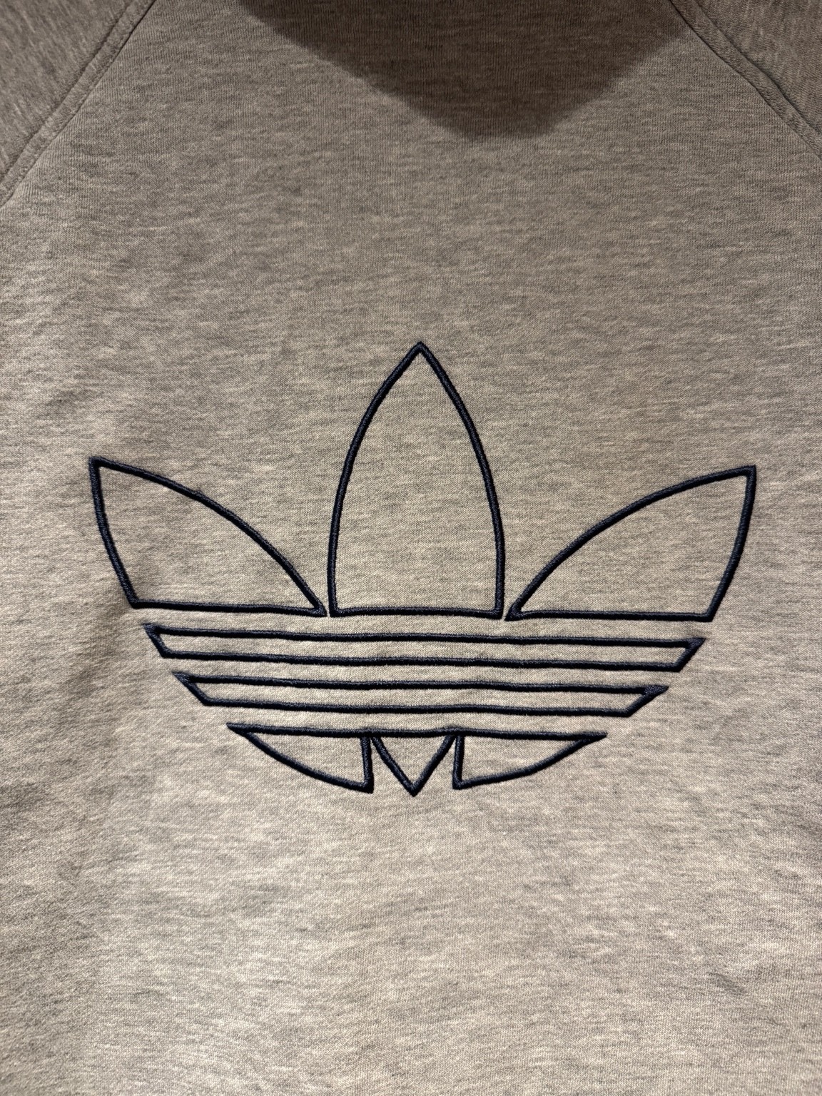 グレースウェット面の背中に施された大きなトレフォイル刺繍のディテール。ネイビー糸でアウトラインをふちどったデザイン。