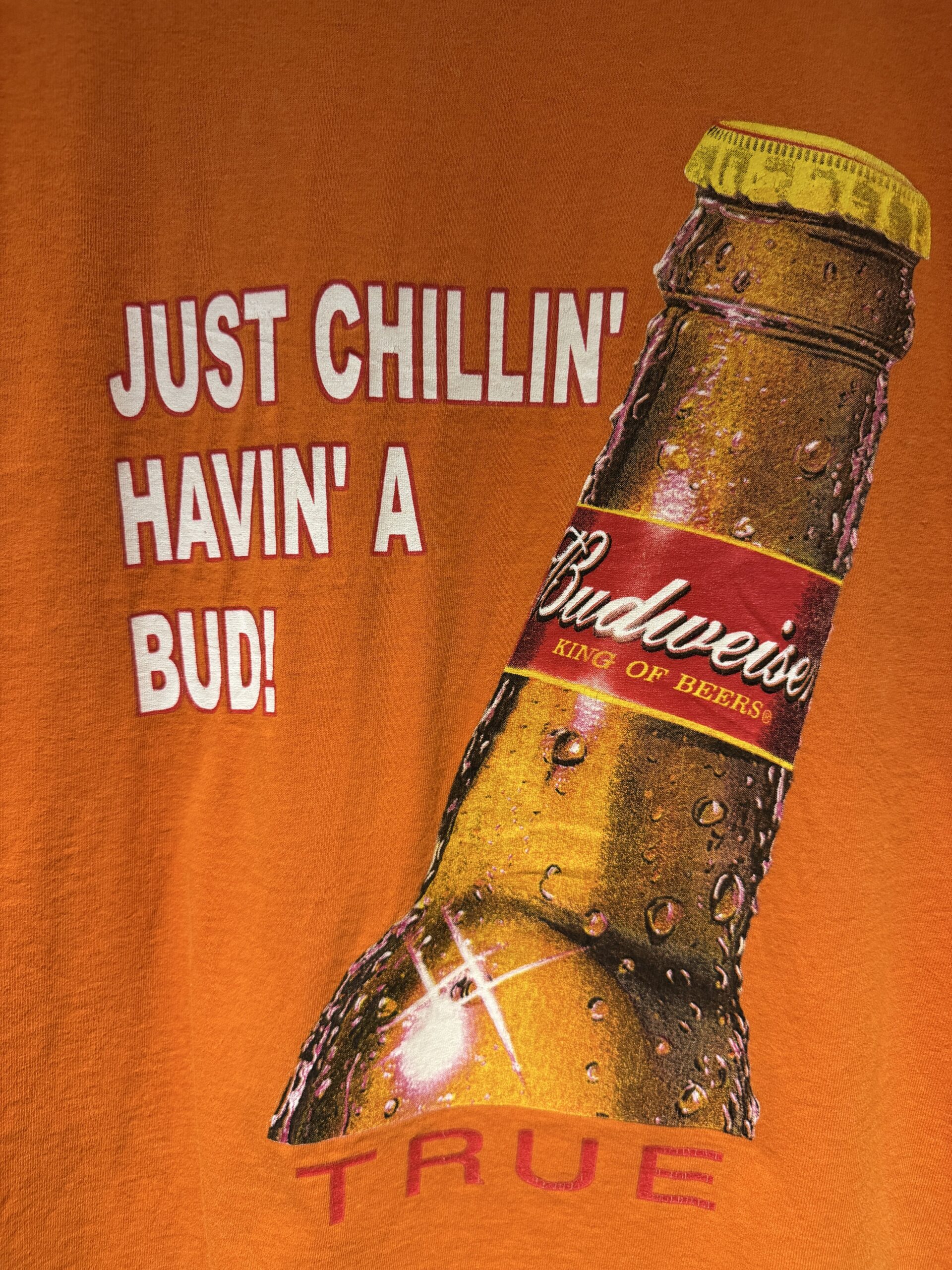 JUST CHILLIN' HAVIN' A BUD! のコピーとBudweiserボトルが大きくプリントされたバックプリントのクローズアップ。