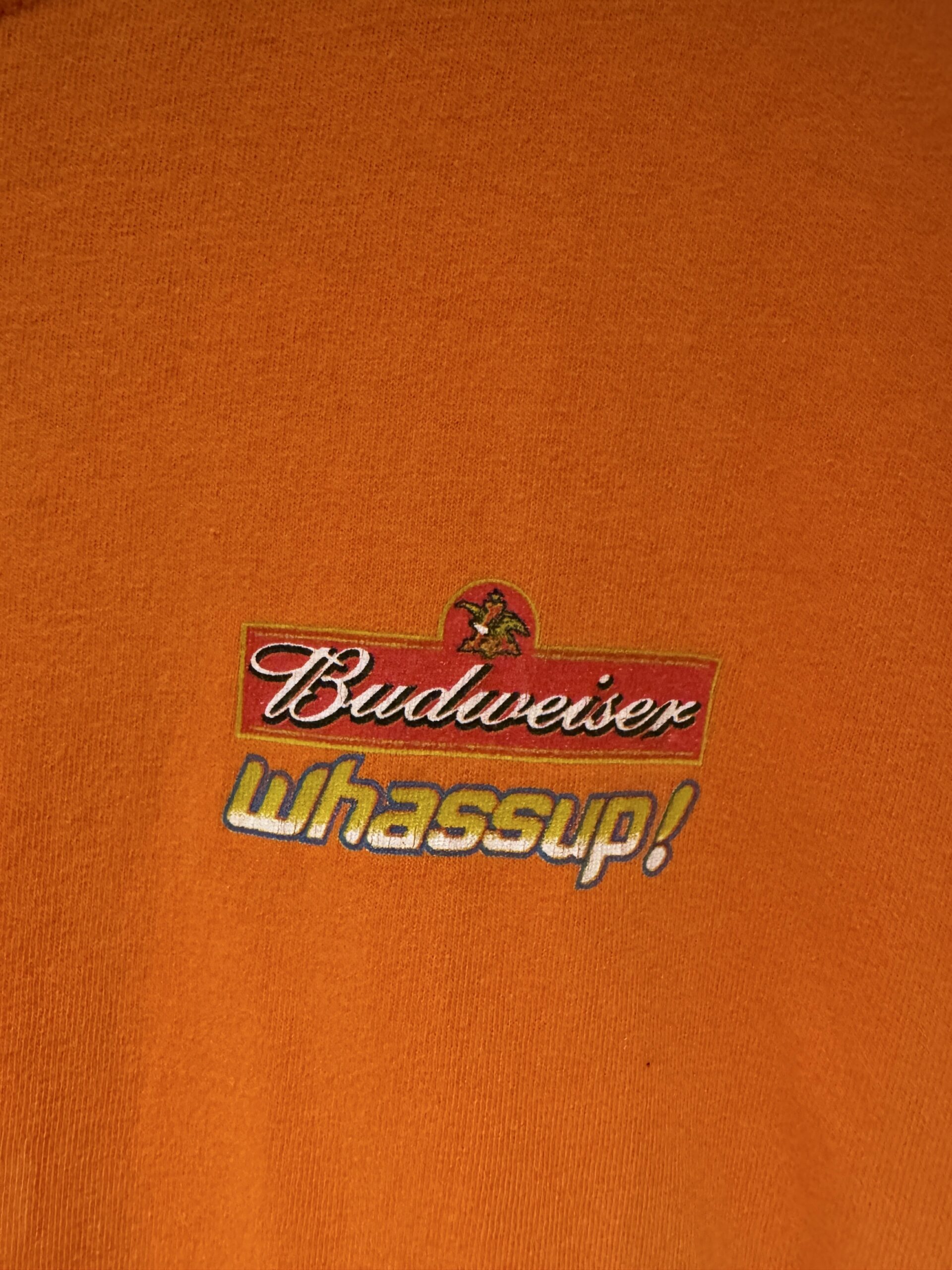 Budweiserロゴと「whassup!」の文字がプリントされた、胸元ワンポイントのアップ写真。