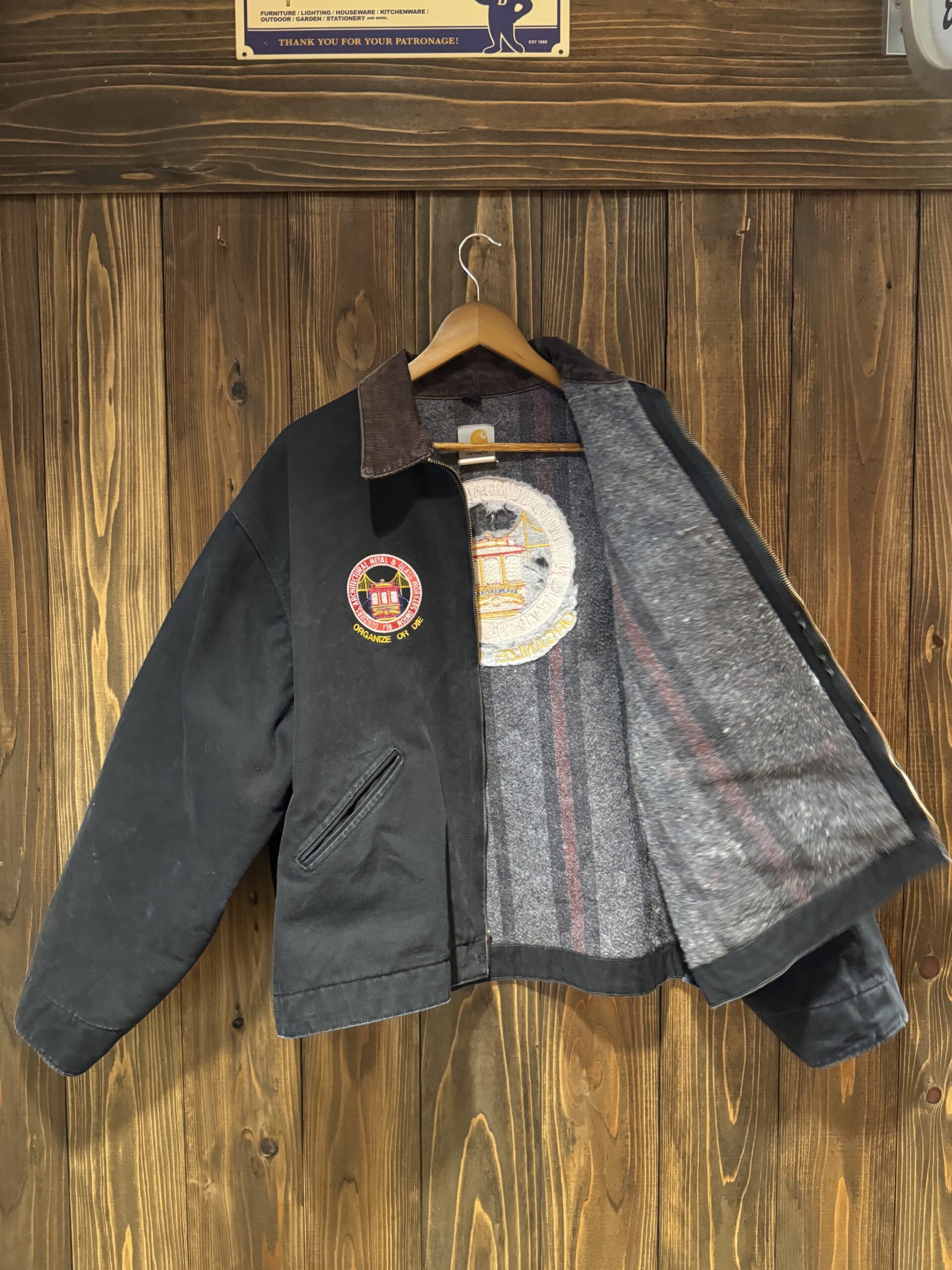 Carhartt企業物ワークジャケットの内側。グレーのブランケットライニングと背中側のワッペン裏が見える。