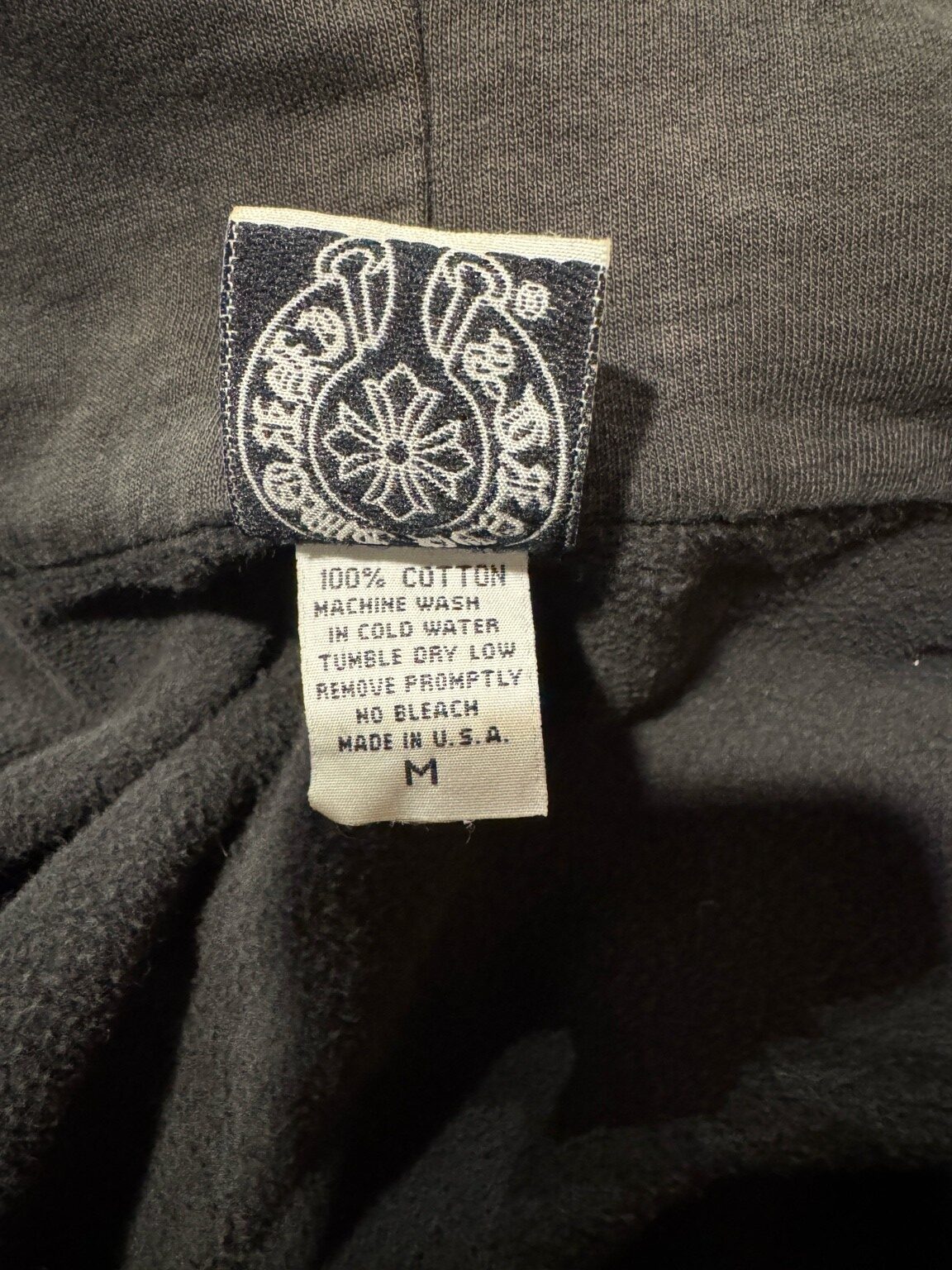 CHROME HEARTSジップパーカーのネームタグと洗濯タグ。ブランドロゴとMADE IN U.S.A表記が見える。