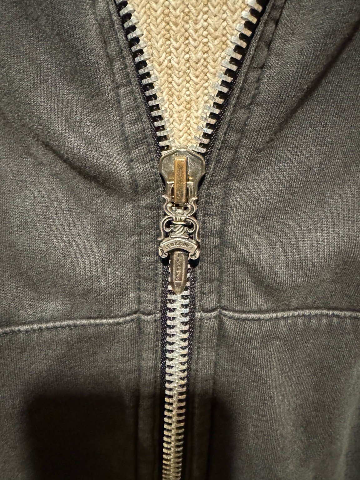 CHROME HEARTSのジップパーカーのRiri社製ジッパーのクローズアップ。長年の使用で少し色が落ち着いた金属パーツ。