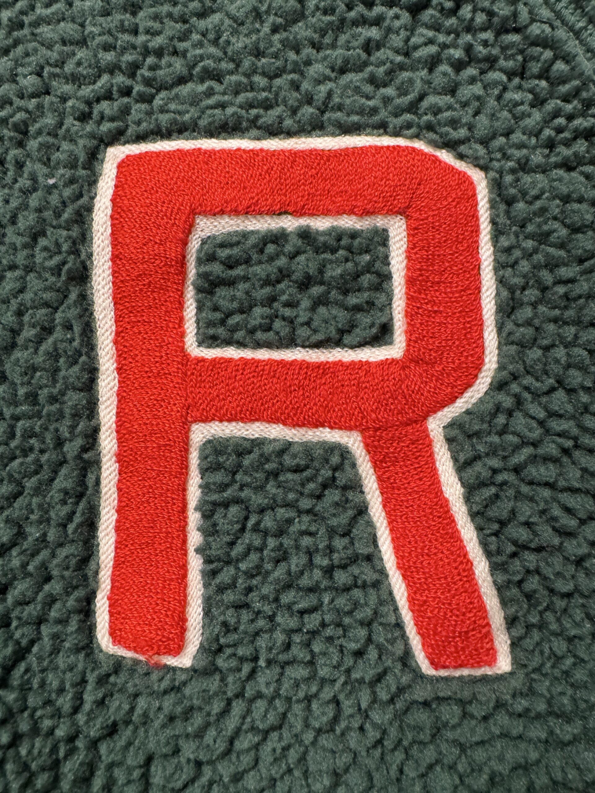 ラルフローレンRUGBYのボアスタジャン胸元のRワッペンの近接画像。