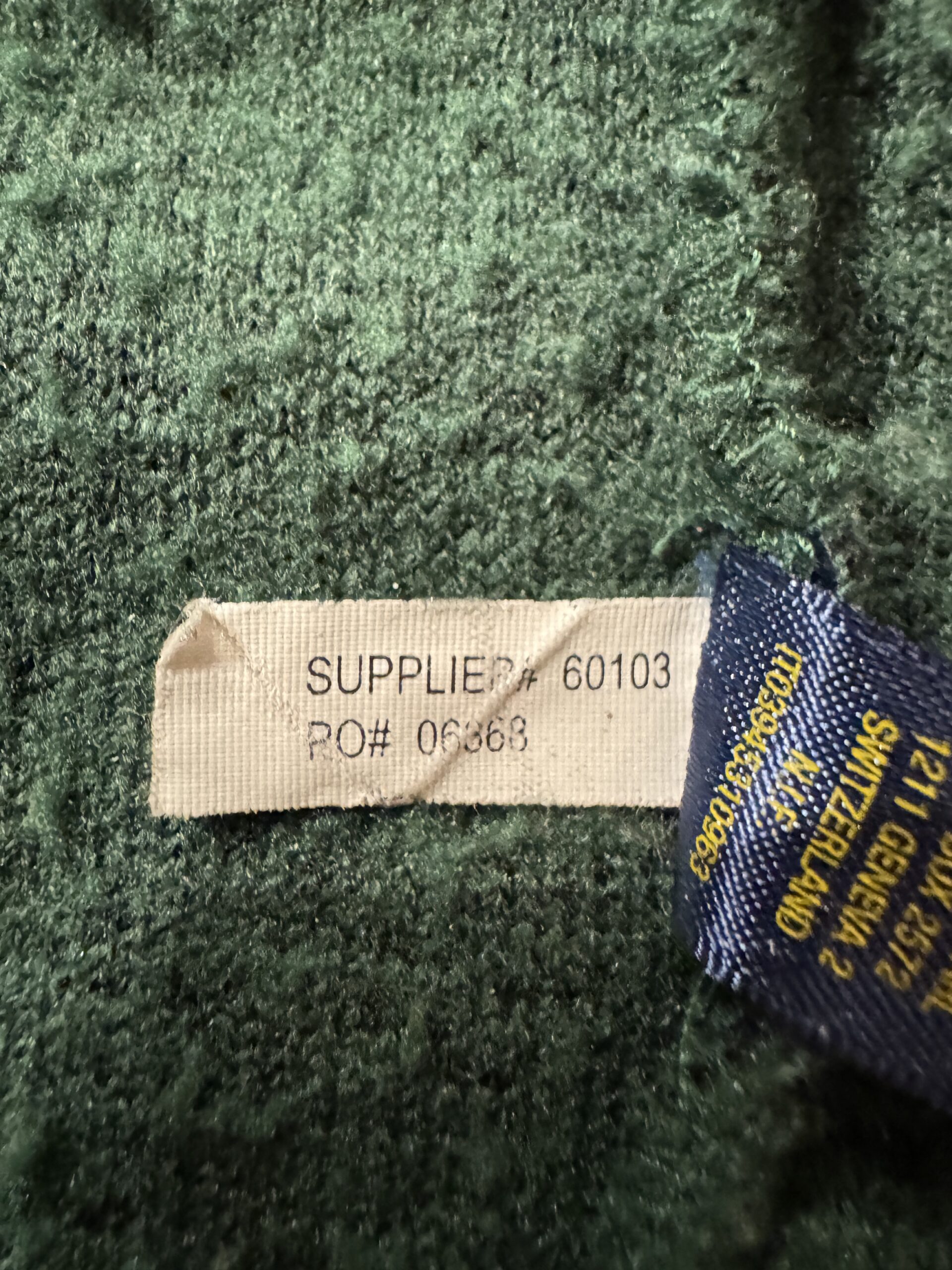 RUGBYボアスタジャンの内側にあるSUPPLIER#とPO番号が記されたタグ。