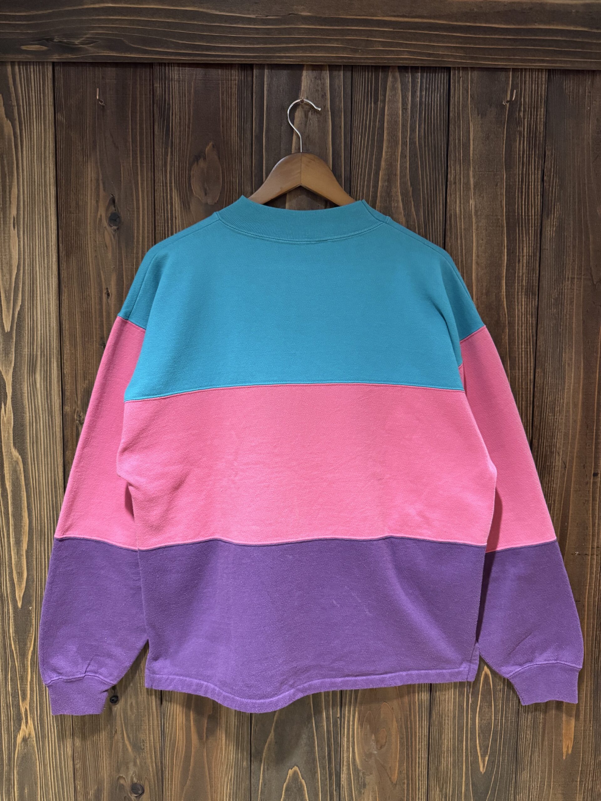 ターコイズ×ピンク×パープルの3色切り替えがきれいな、STEAMBOAT COLORADOスウェットのバックスタイル（ハンガー掛け）。