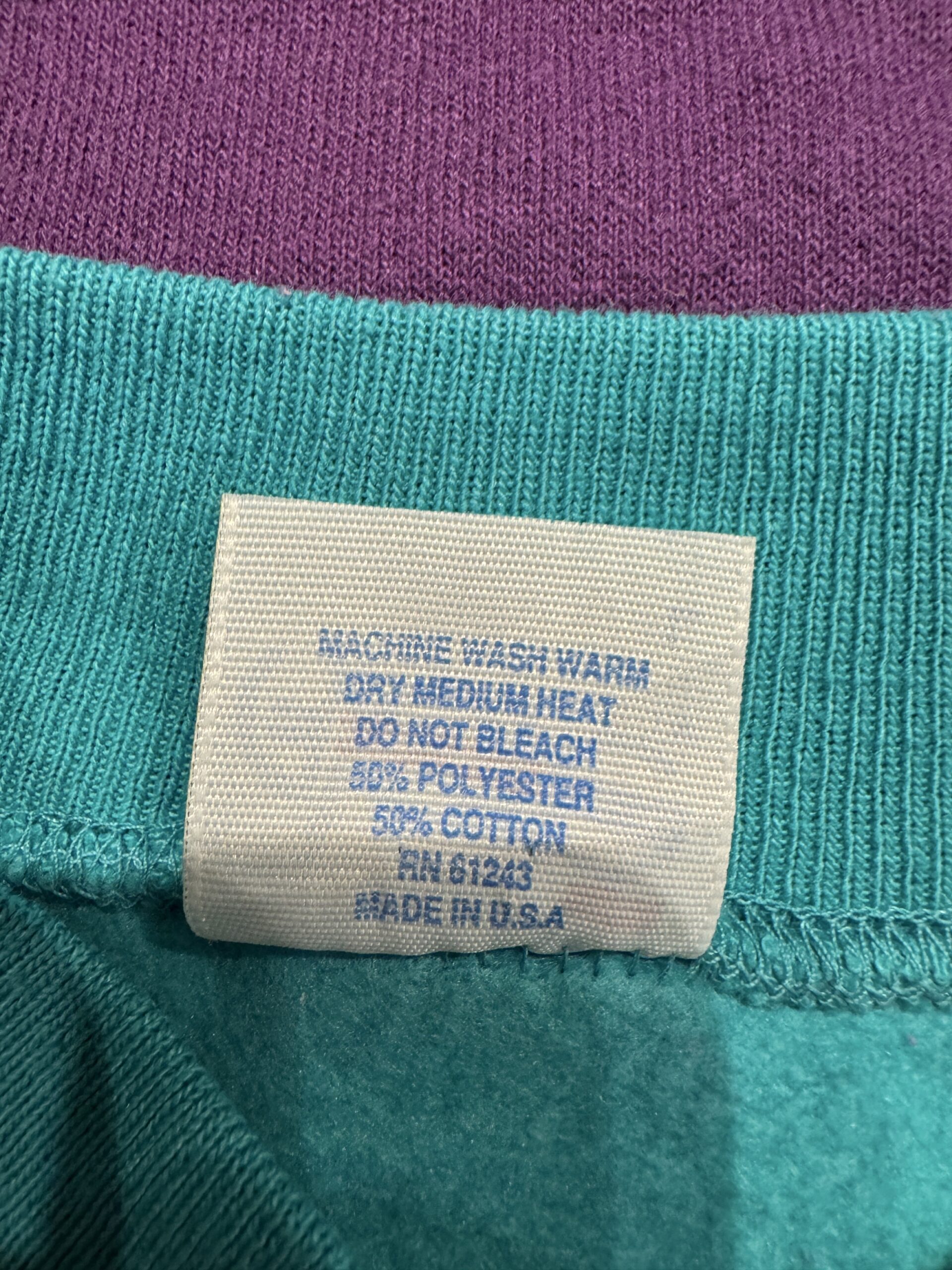 MACHINE WASH WARM表記入りのケアタグ。50％コットン・50％ポリエステルのブレンド生地で、MADE IN U.S.A表記。