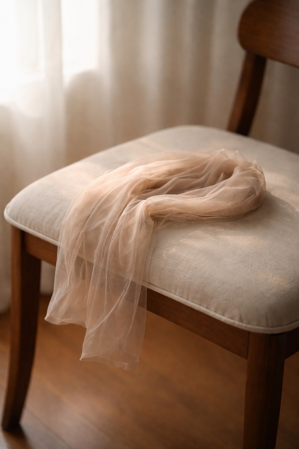 柔らかな光の中、椅子に置かれたナイロンストッキング。布の薄さと陰影が静かに伝わる写真