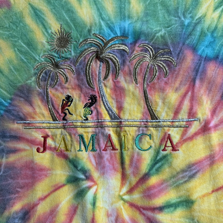 ヤシの木と二人の人物とJAMAICAの文字が刺繍された胸元デザイン