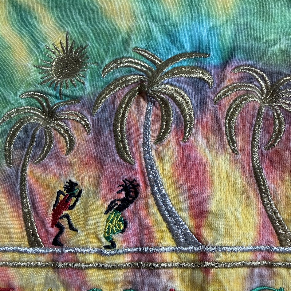 銀糸で表現されたヤシの木と太陽の刺繍ディテール